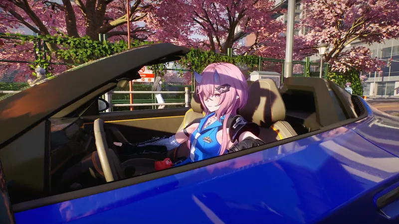 Richie driving a blue convertible under pink cherry blossoms